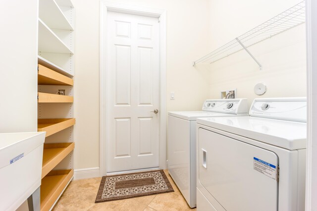 laundry area with washer and clothes dryer and light tile patterned flooring