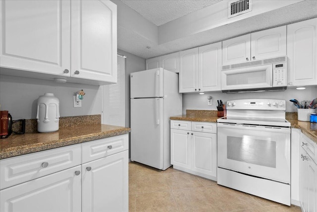 kitchen with white cabinets, light tile patterned flooring, white appliances, and a textured ceiling