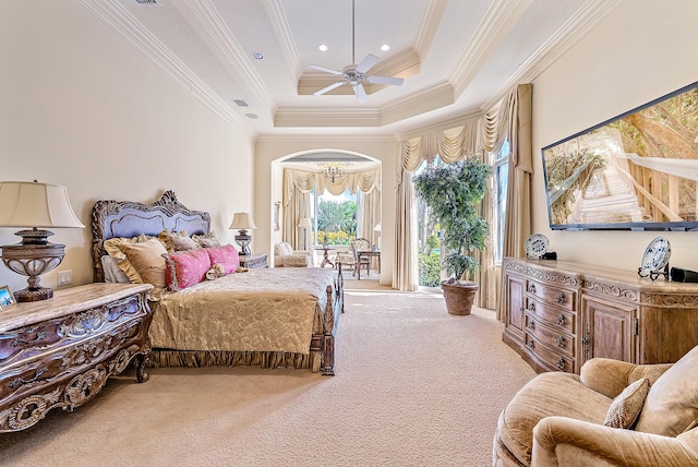 bedroom with a towering ceiling, ornamental molding, light colored carpet, a raised ceiling, and ceiling fan