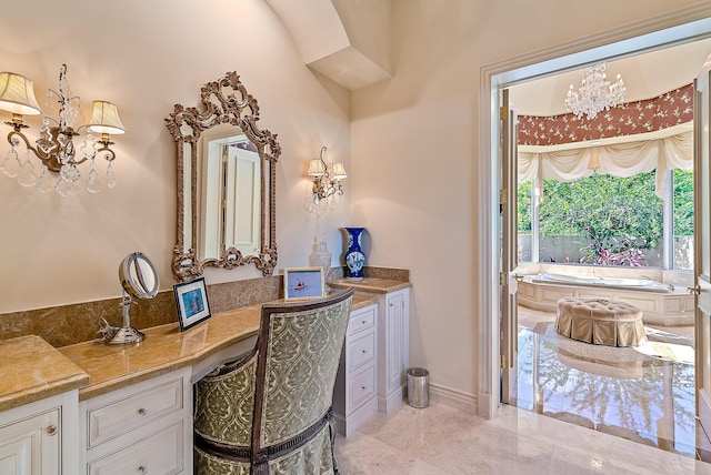 bathroom with a bathing tub, vanity, and an inviting chandelier