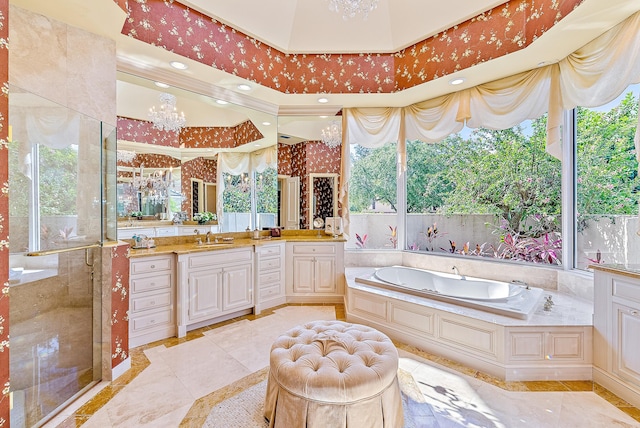 bathroom featuring a notable chandelier, vanity, and independent shower and bath