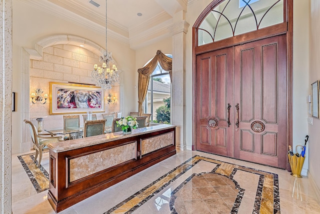 entrance foyer featuring crown molding and a chandelier