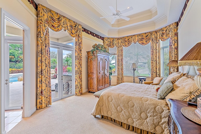 bedroom featuring access to exterior, ceiling fan, crown molding, a tray ceiling, and light carpet