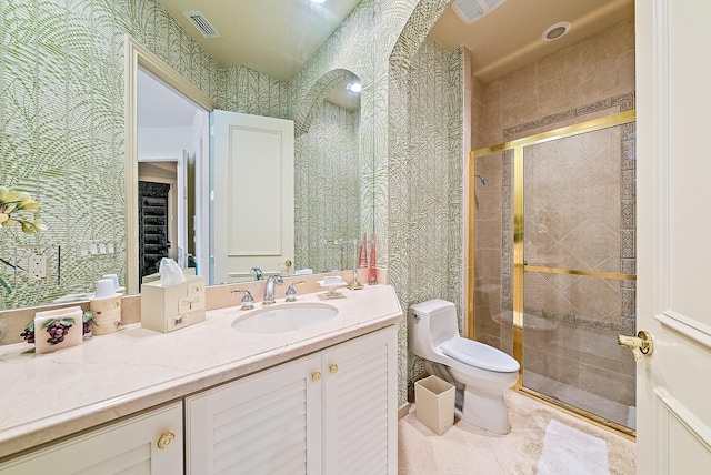 bathroom with tile patterned floors, a shower with door, vanity, and toilet