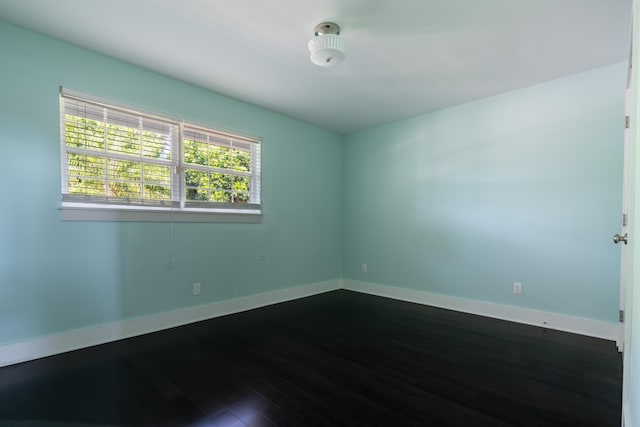 unfurnished room with dark hardwood / wood-style flooring