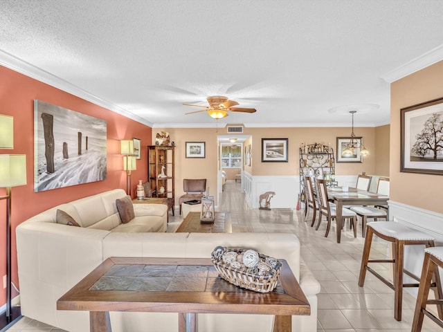 living room featuring crown molding, light tile patterned floors, and a textured ceiling