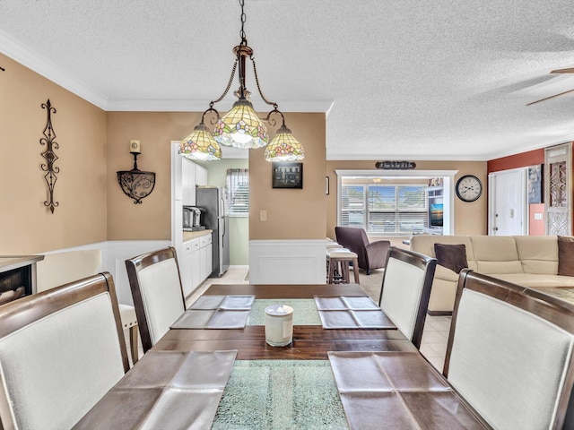 dining area with crown molding, a textured ceiling, and hardwood / wood-style flooring