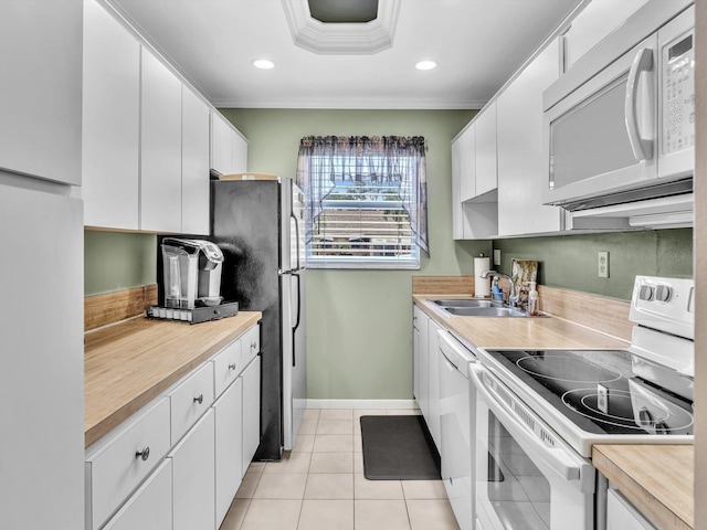 kitchen with white cabinetry, sink, crown molding, white appliances, and light tile patterned floors