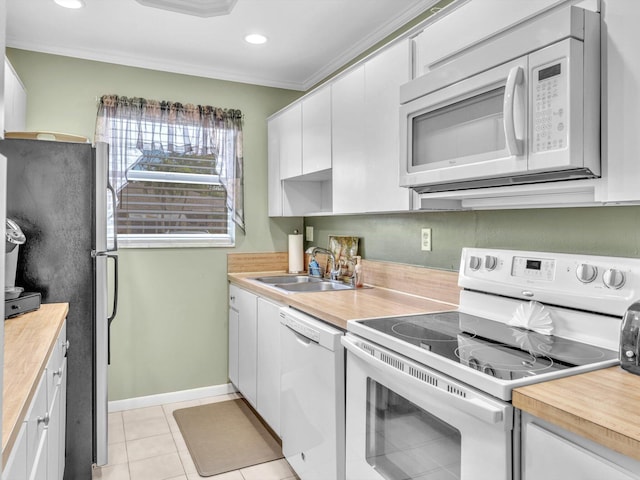 kitchen with white appliances, white cabinets, crown molding, sink, and light tile patterned floors