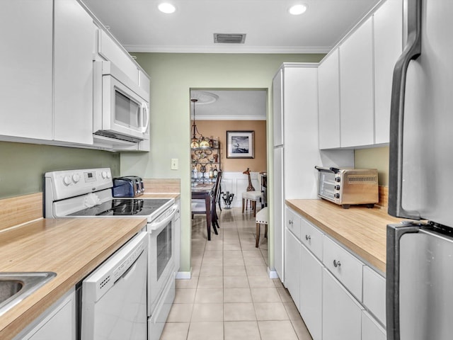 kitchen with ornamental molding, white appliances, sink, light tile patterned floors, and white cabinets