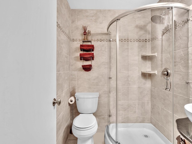 bathroom with toilet and a shower with shower door