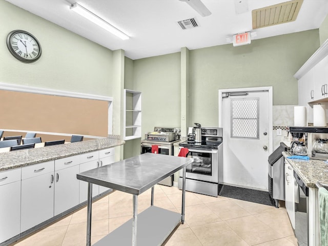 kitchen with light stone counters, white cabinetry, stainless steel range with electric cooktop, and light tile patterned floors