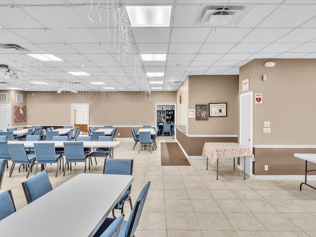 tiled dining area with a paneled ceiling