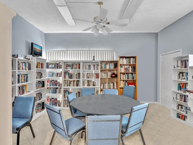 dining area with ceiling fan, light tile patterned floors, and a textured ceiling