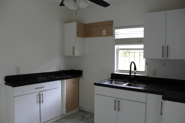 kitchen with white cabinetry, sink, and ceiling fan