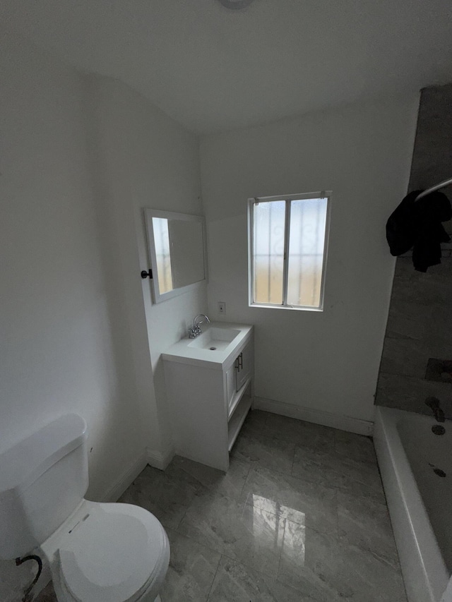 bathroom featuring vanity, a bathtub, and toilet