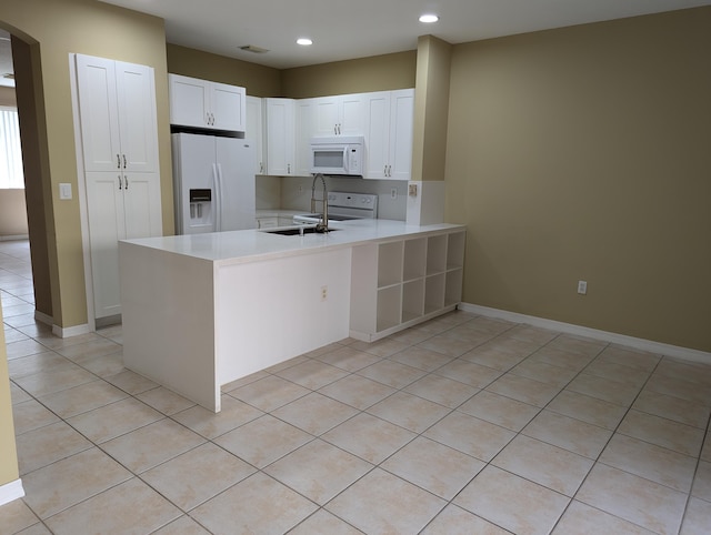 kitchen with white cabinets, white appliances, sink, and light tile patterned floors