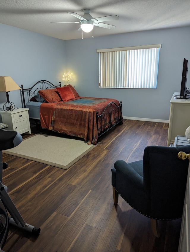 bedroom featuring ceiling fan, dark hardwood / wood-style flooring, and a textured ceiling