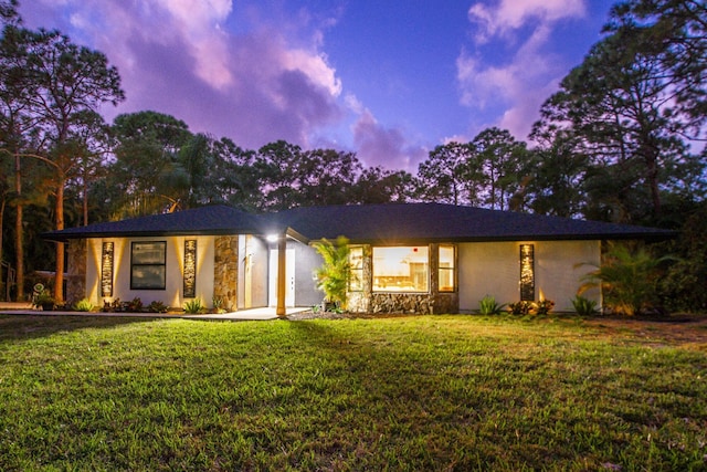 ranch-style home with a yard