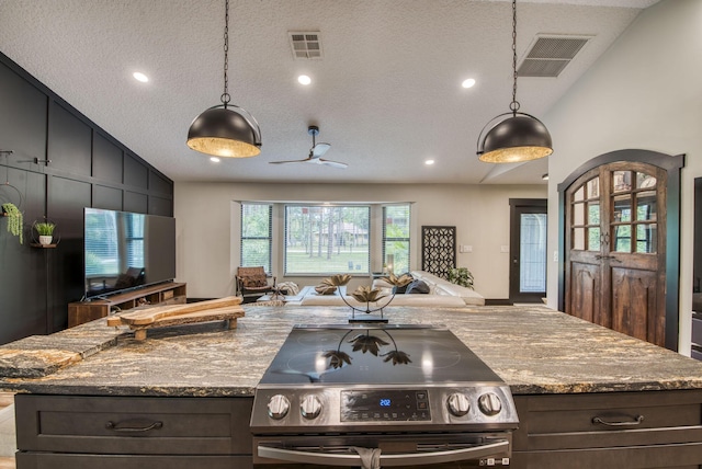 kitchen with a textured ceiling, decorative light fixtures, lofted ceiling, and stainless steel electric range