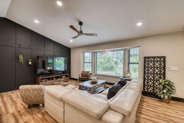 living room featuring ceiling fan, a healthy amount of sunlight, vaulted ceiling, and light hardwood / wood-style flooring