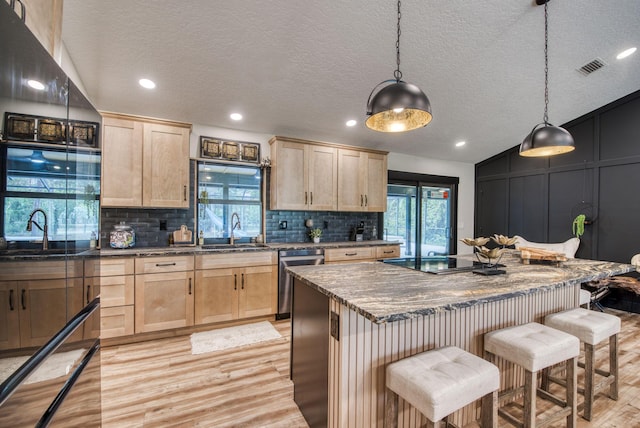 kitchen with dishwasher, light brown cabinetry, lofted ceiling, and light hardwood / wood-style flooring