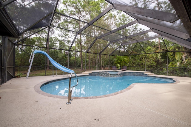 view of pool with a lanai, a patio area, an in ground hot tub, and a water slide