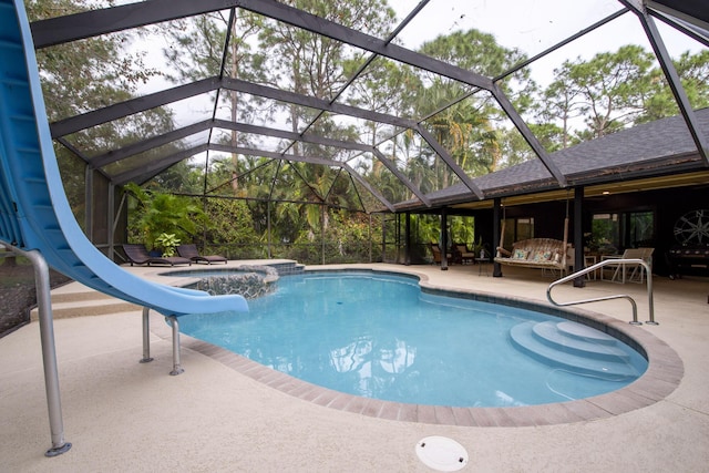 view of swimming pool featuring a lanai, an in ground hot tub, a water slide, and a patio