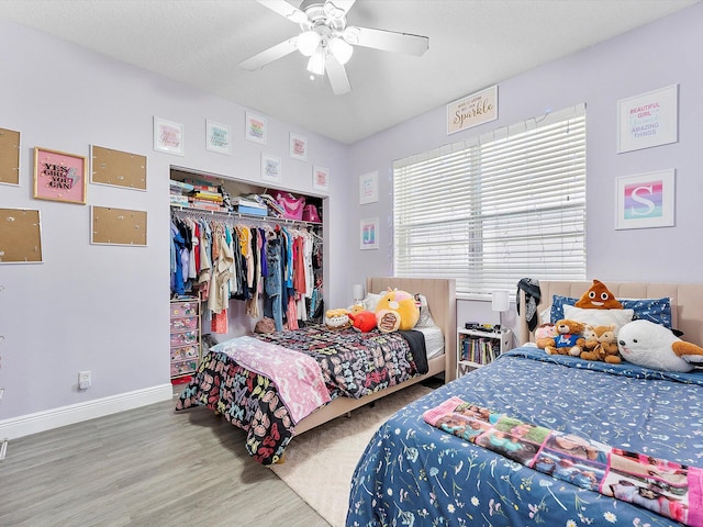 bedroom with ceiling fan, wood-type flooring, and a closet