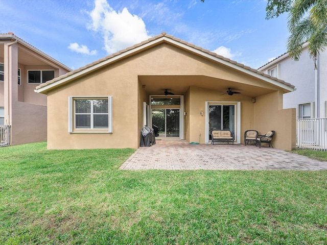 back of property with a patio, ceiling fan, and a lawn