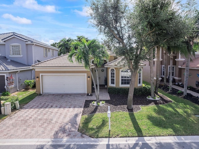 mediterranean / spanish-style home with a front lawn and a garage