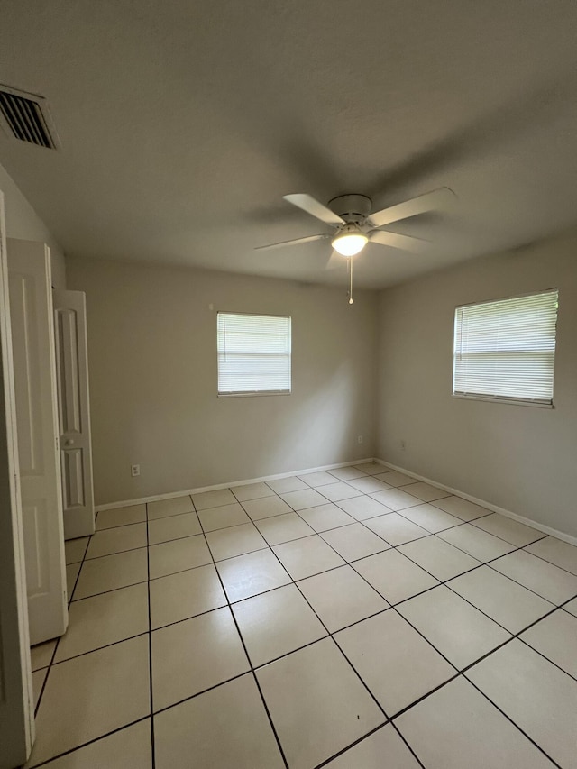 tiled empty room with ceiling fan