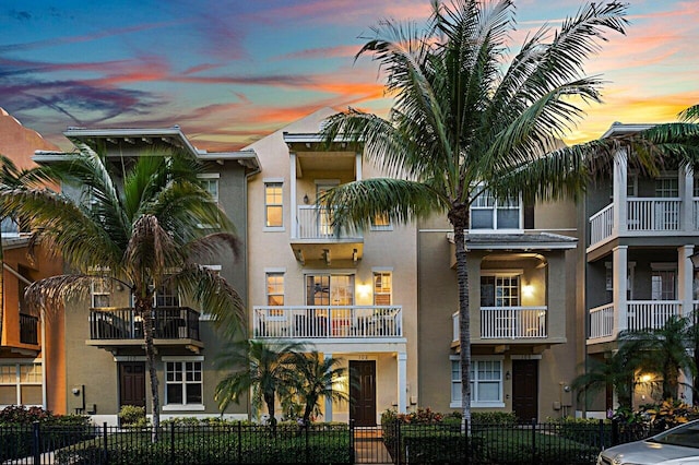 property at dusk featuring a fenced front yard