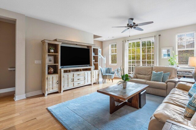 living room with light wood-type flooring and ceiling fan