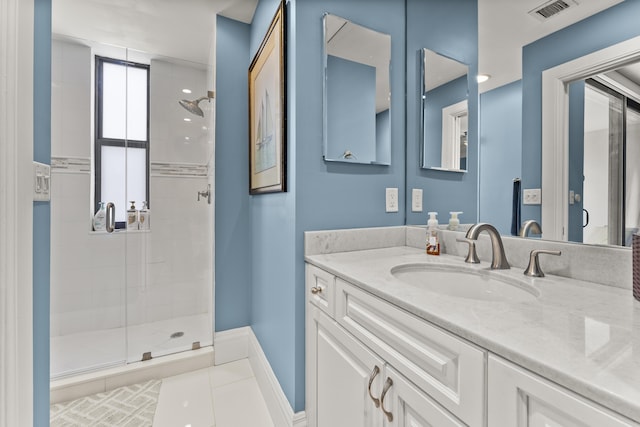 bathroom with tile patterned flooring, vanity, and a shower with shower door