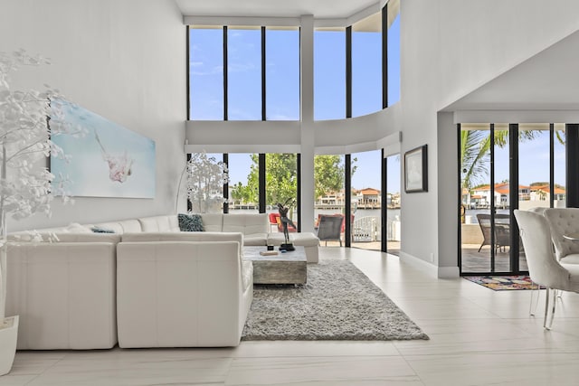 living room featuring a water view and light tile patterned flooring