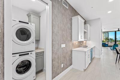 laundry room with cabinets, ceiling fan, and stacked washer and clothes dryer