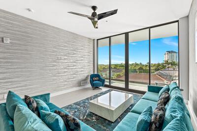 living room with a wall of windows and ceiling fan