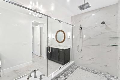 bathroom with tiled shower and vanity