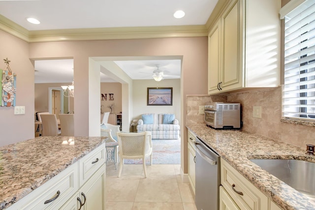 kitchen with cream cabinetry, dishwasher, and light stone countertops