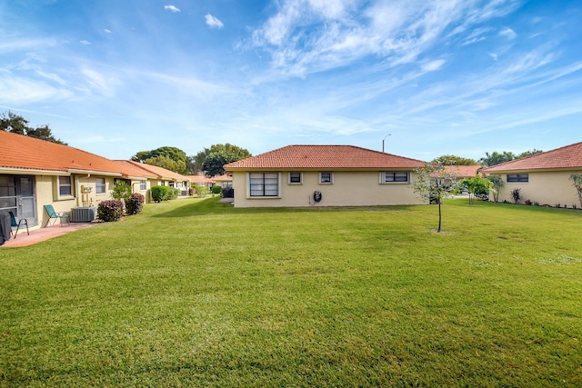 back of house featuring a lawn and central AC unit