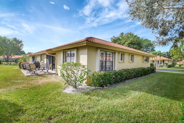 view of home's exterior with a lawn and a patio