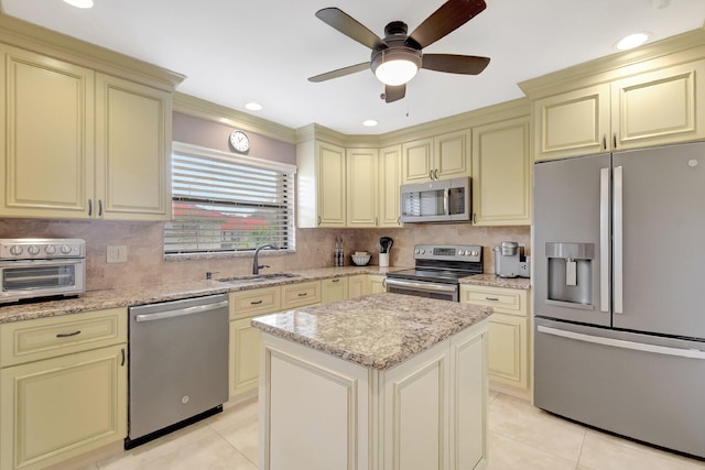 kitchen featuring cream cabinetry, light tile patterned floors, a center island, and stainless steel appliances