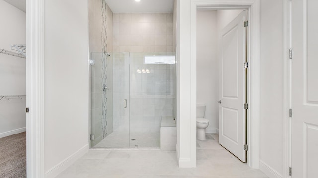 bathroom featuring tile patterned floors, a shower with door, and toilet