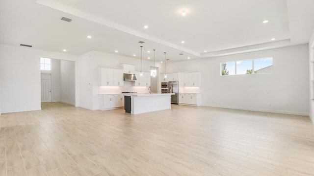 unfurnished living room featuring sink and light wood-type flooring