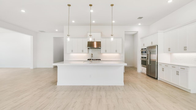 kitchen with pendant lighting, white cabinets, light wood-type flooring, and appliances with stainless steel finishes