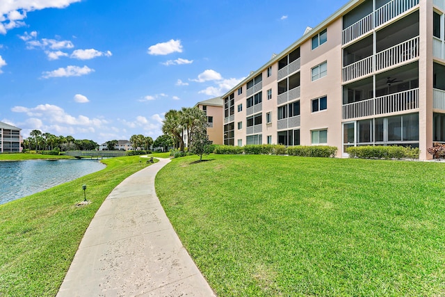 view of property's community featuring a lawn and a water view