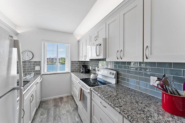 kitchen with decorative backsplash, light wood-type flooring, light stone counters, white appliances, and white cabinetry