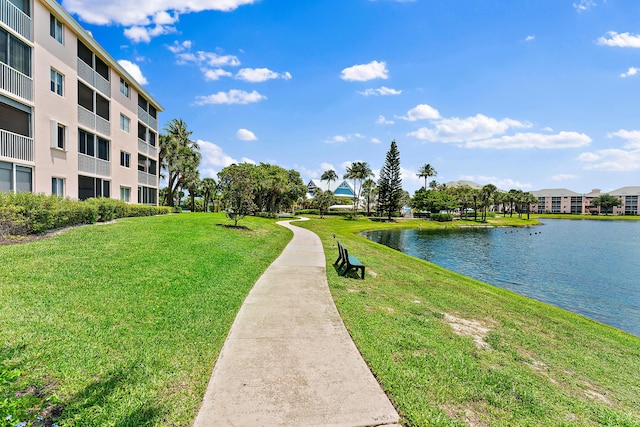 view of home's community with a lawn and a water view