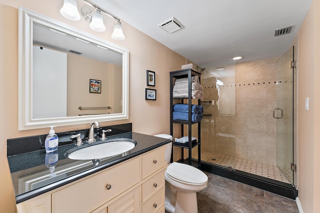 bathroom with vanity, a shower with shower door, and toilet